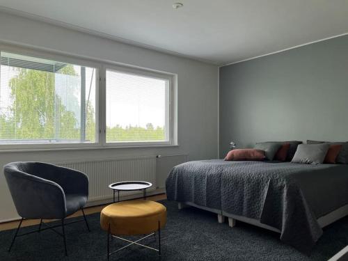 a bedroom with a bed and a chair and a window at Studiohuoneisto Liisankatu in Lappeenranta