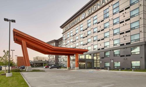 a large building with a large wooden structure in front of it at Sandman Signature Plano-Frisco Hotel in Plano