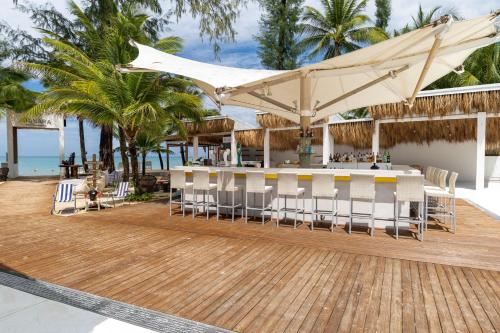restauracja na plaży ze stołem i krzesłami w obiekcie Arinara Beach Resort Phuket - SHA Extra Plus w mieście Bang Tao Beach