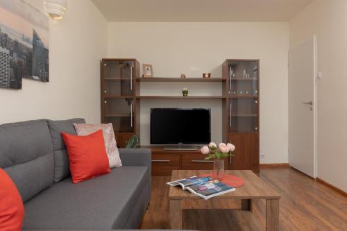 sala de estar con sofá gris y TV en Warsaw Praga Two-bedroom Apartment Kobielska by Renters, en Varsovia