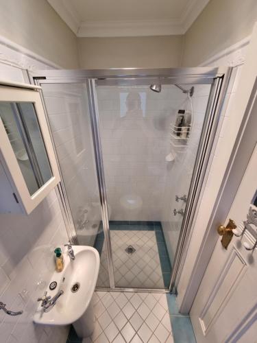 a bathroom with a shower and a sink at Shelton-Lea in Katoomba