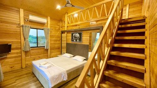 Habitación con cama y escalera en una cabaña en The Arowana Divine, en Nanded