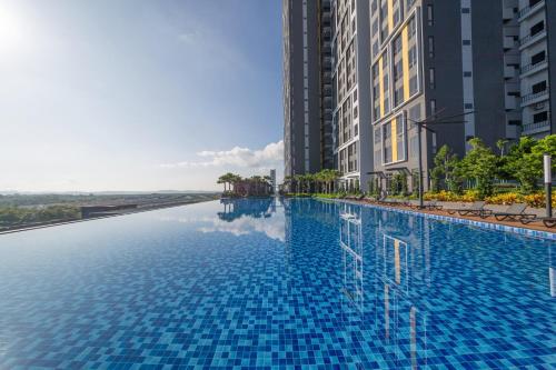 uma piscina no meio de dois edifícios altos em Sunway Grid Loft Suite by Nest Home【Olympic Size Pool】 em Kampong Pendas