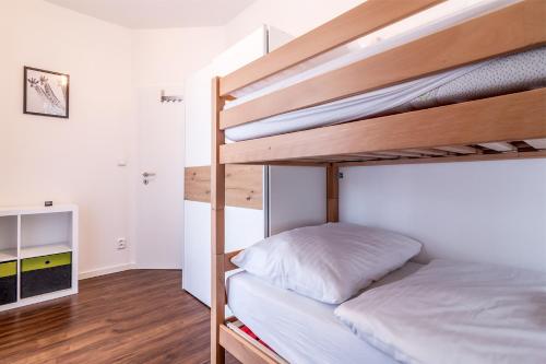 a bedroom with two bunk beds and a desk at Lipno - Lakeside Village - Větrník in Frymburk