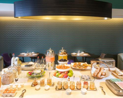 ブローニュ・ビヤンクールにあるHotel Acanthe - Boulogne Billancourtの食べ物のビュッフェ付きテーブル