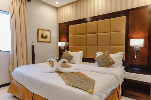 a bedroom with a large bed with swans on it at Al Butat Al Mummayza in Jeddah