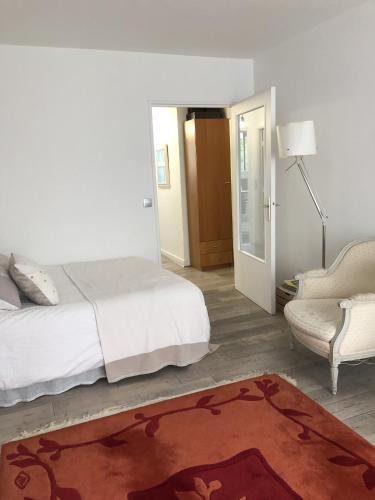 une chambre avec un lit, une chaise et un tapis dans l'établissement Studio tout confort gare de Lyon - possibilité parking, à Paris