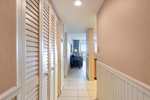 a hallway with a person sitting in a chair in a room at Atlantica Towers Condo w Balcony by Hosteeva in Myrtle Beach