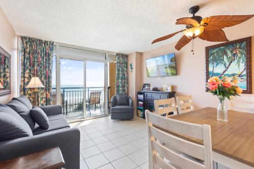 a dining room and living room with a table and a couch at Atlantica Towers Condo w Balcony by Hosteeva in Myrtle Beach