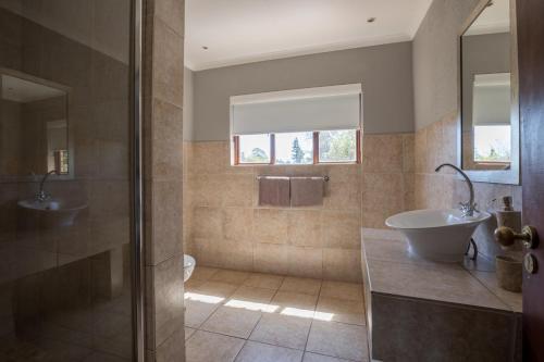 y baño con bañera, lavamanos y ducha. en Greenway Woods Accommodation en White River