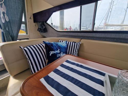 a table and two pillows on a boat at *NEW* GORGEOUS BOAT STAY WITH VIEWS! in Brixham