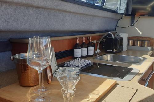 two wine glasses sitting on top of a kitchen counter at *NEW* GORGEOUS BOAT STAY WITH VIEWS! in Brixham