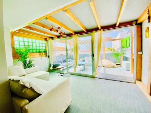 Golden Wave Surf Roof Terrace في كوراليخو: غرفة معيشة مع أريكة ونافذة كبيرة