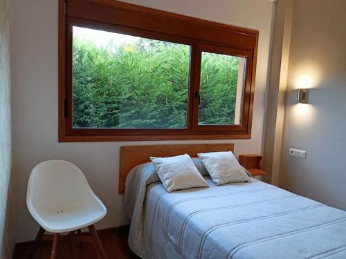 - une chambre avec un lit, une fenêtre et une chaise dans l'établissement Bandos, refugio natural, à Cines