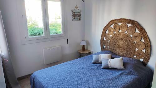 - une chambre avec un lit bleu et une grande tête de lit dans l'établissement T3 45M2, Cap d'Adge,Secteur Falaise,4-6 pers, Clim, Fibre - WIFI, 100m plage, au Cap d'Agde