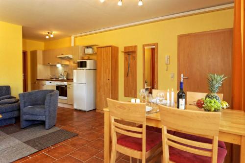 a kitchen and living room with a table and chairs at Haus Grete Wohnung 12 in Ostseebad Koserow