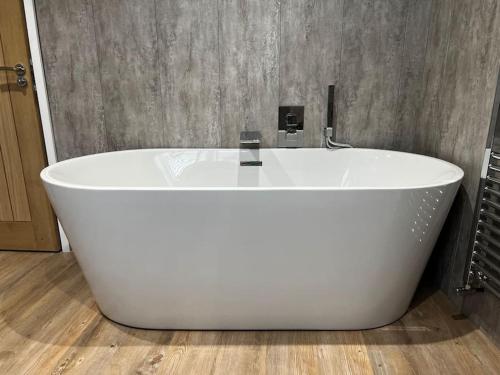 La salle de bains est pourvue d'une grande baignoire blanche. dans l'établissement Ulverston stunning 1 bedroom apartment, à Ulverston