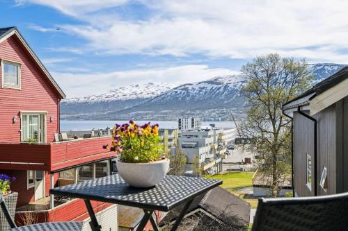 a table with a vase of flowers on a balcony at Cozy little house in Tromsø city in Tromsø