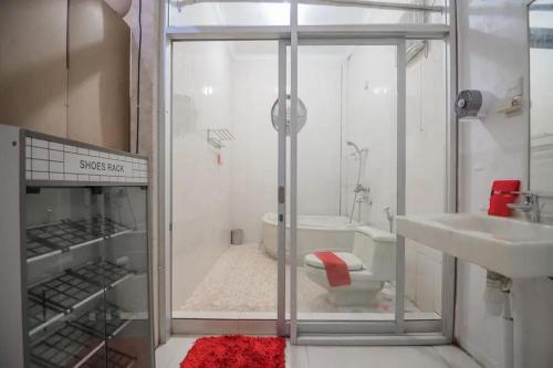 uma casa de banho com um chuveiro, um lavatório e um WC. em RedDoorz Syariah at Jalan Ahmad Yani Jambi em Jambi