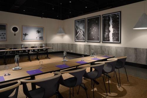 a room with a long table and chairs at QT Gold Coast in Gold Coast