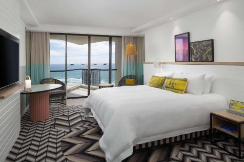 Habitación de hotel con cama grande y balcón. en QT Gold Coast en Gold Coast