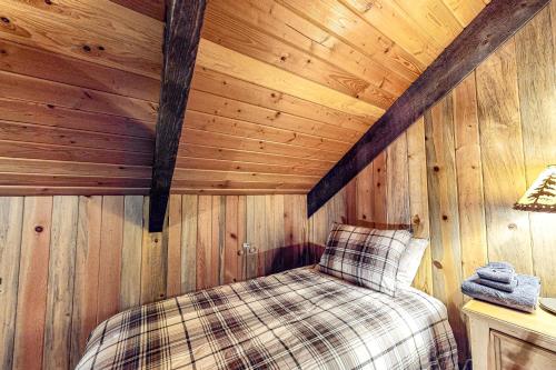 a bedroom with a bed in a wooden cabin at Blue Pine Lodge in Joseph