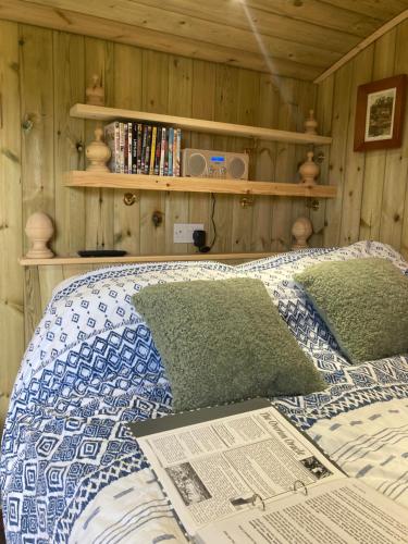 a bedroom with a bed with a newspaper on it at The Dragon's Hut with cozy logburner in Wrexham