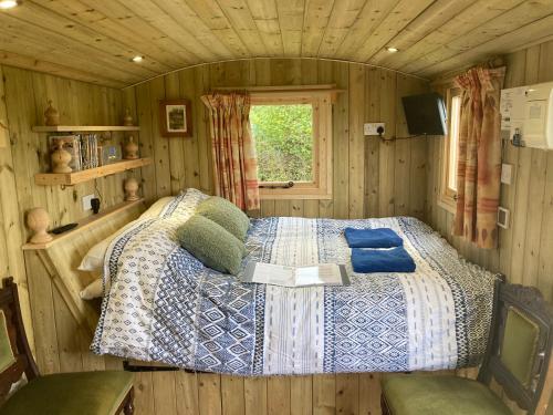 a bedroom with a bed in a wooden cabin at The Dragon's Hut with cozy logburner in Wrexham