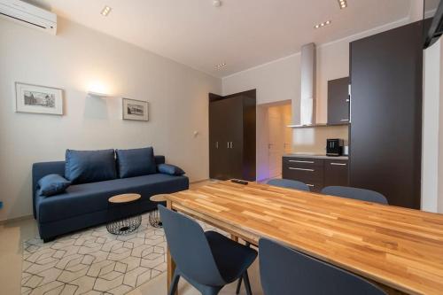 salon z niebieską kanapą i kuchnią w obiekcie Levestate Apartments Klährgasse Vol 2 w Wiedniu