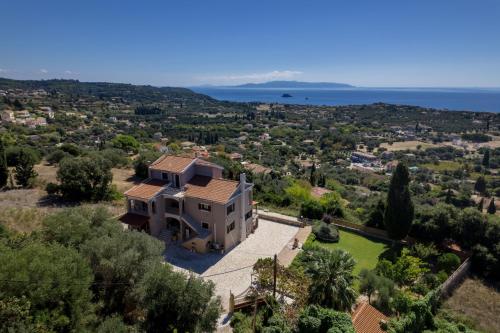 Una vista aérea de una casa con el océano al fondo. en Vivian's Villa - Endless View, en Svoronata
