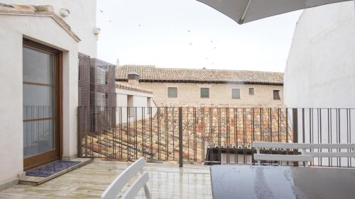 a balcony with white chairs and a fence at Apartamentos Virgen Blanca in Toledo