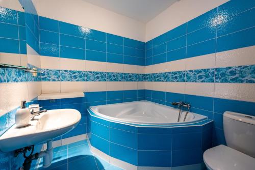 ein blau-weißes Bad mit einer Badewanne und einem Waschbecken in der Unterkunft Apartmán Hartmanice in Sušice