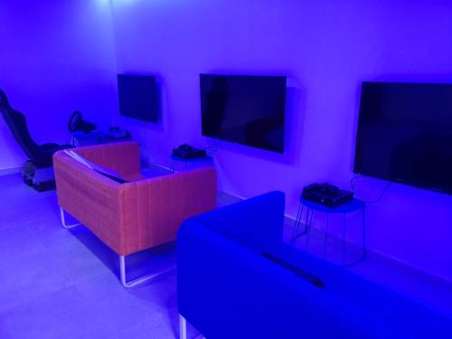 a living room with a couch and three televisions at Bab Al Shams Resort in Jericho
