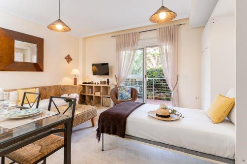 een slaapkamer met een bed, een tafel en een raam bij BLONZU SAFARi in Benalmádena