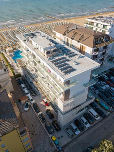 an aerial view of a building with cars parked in a parking lot at Hotel Galassia Suites & Spa in Lido di Jesolo