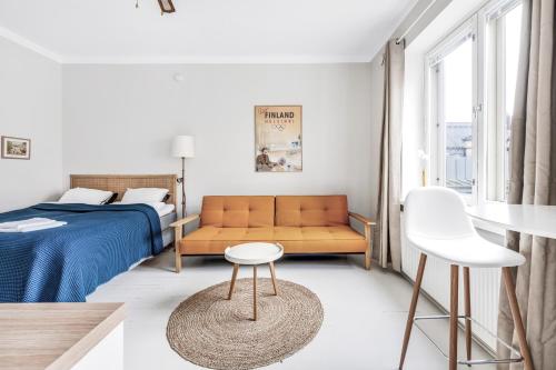 - une chambre avec un lit et un canapé dans l'établissement Central Designers Studio WeHost Albertinkatu, à Helsinki
