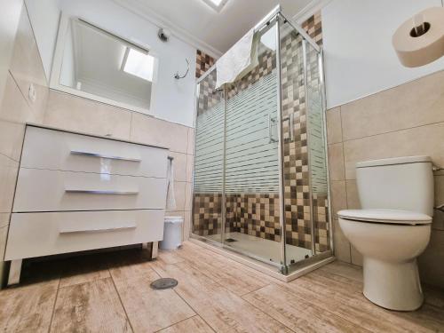 ein Badezimmer mit Toilette und Glasdusche in der Unterkunft Bungalows Teresa in Playa del Ingles