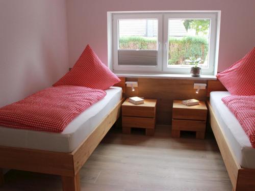 two beds in a small room with a window at Ferienhaus Gerda in Wangerland