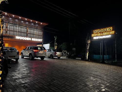 a group of cars parked in a parking lot at night at Wooden ECR Sea Resort in Puducherry