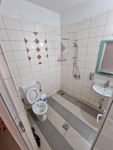 a bathroom with a toilet and a sink at Hotel Yal Restaurant in Tetovo