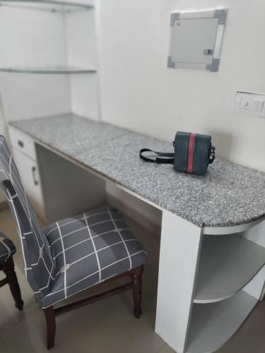 a bag sitting on a desk with a chair at Entire Studio Apt/Suite near Mall/Metro/ExpoMart in Noida