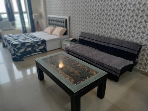 a living room with a couch and a coffee table at Entire Studio Apt/Suite near Mall/Metro/ExpoMart in Noida