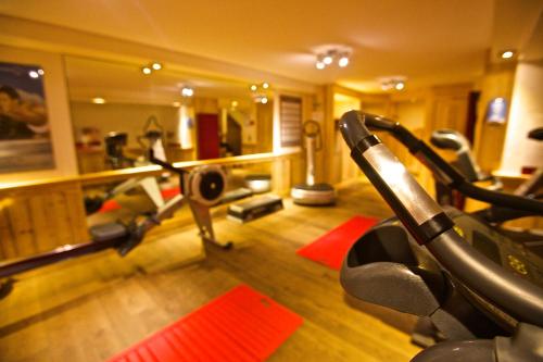 a fitness room with a gym with tread machines at Hôtel Chalet Mounier in Les Deux Alpes