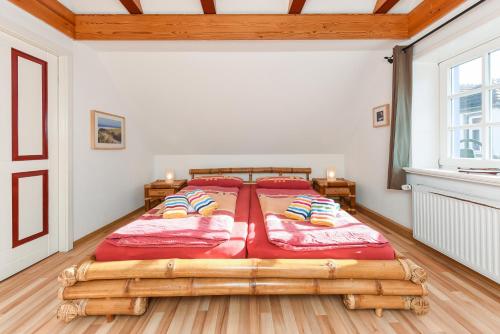 エセンスにあるFerienwohnungen Oll Freesenhuusのベッドルーム1室(木製ベッド1台、赤いシーツ付)