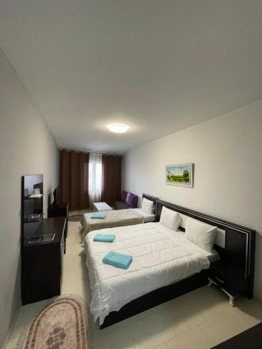 a hotel room with two beds and a desk at Hotel Yal Restaurant in Tetovo
