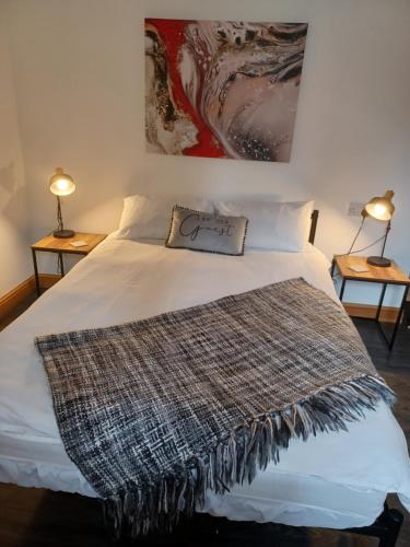 a bedroom with a bed with a blanket on it at Bear Apartments in Rhayader