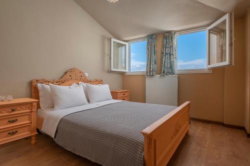 een slaapkamer met een groot bed en 2 ramen bij Melanthi Urban in Volos