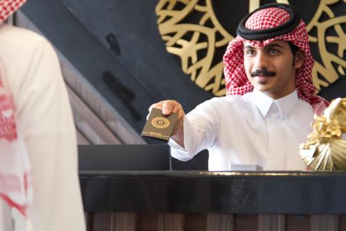 a man is holding up a piece of gold at رفاف أبها للأجنحة الفندقية2 in Sirr Āl Ghalīz̧