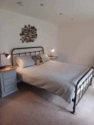 a bedroom with a bed with a metal frame and two lamps at 2 Bear Barns in Rhayader