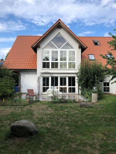 een wit huis met een rood dak bij Ferienwohnung Villa Hygge in Mitterteich